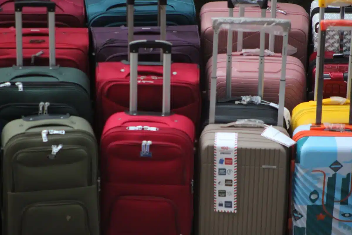 Calciatore con valigia scende le scale di un aeroporto italiano
