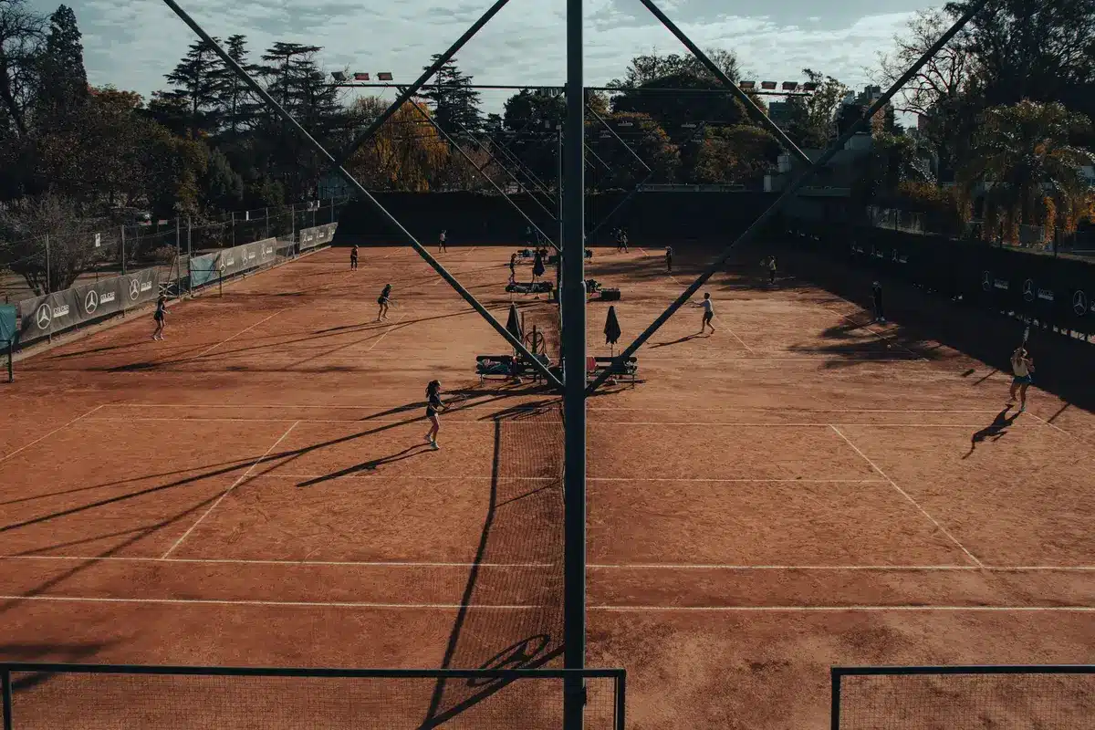 Tennisti in azione su campo in cemento durante una partita di torneo