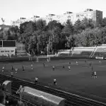 Spettatori allo stadio durante una partita di calcio serale con grande tensione