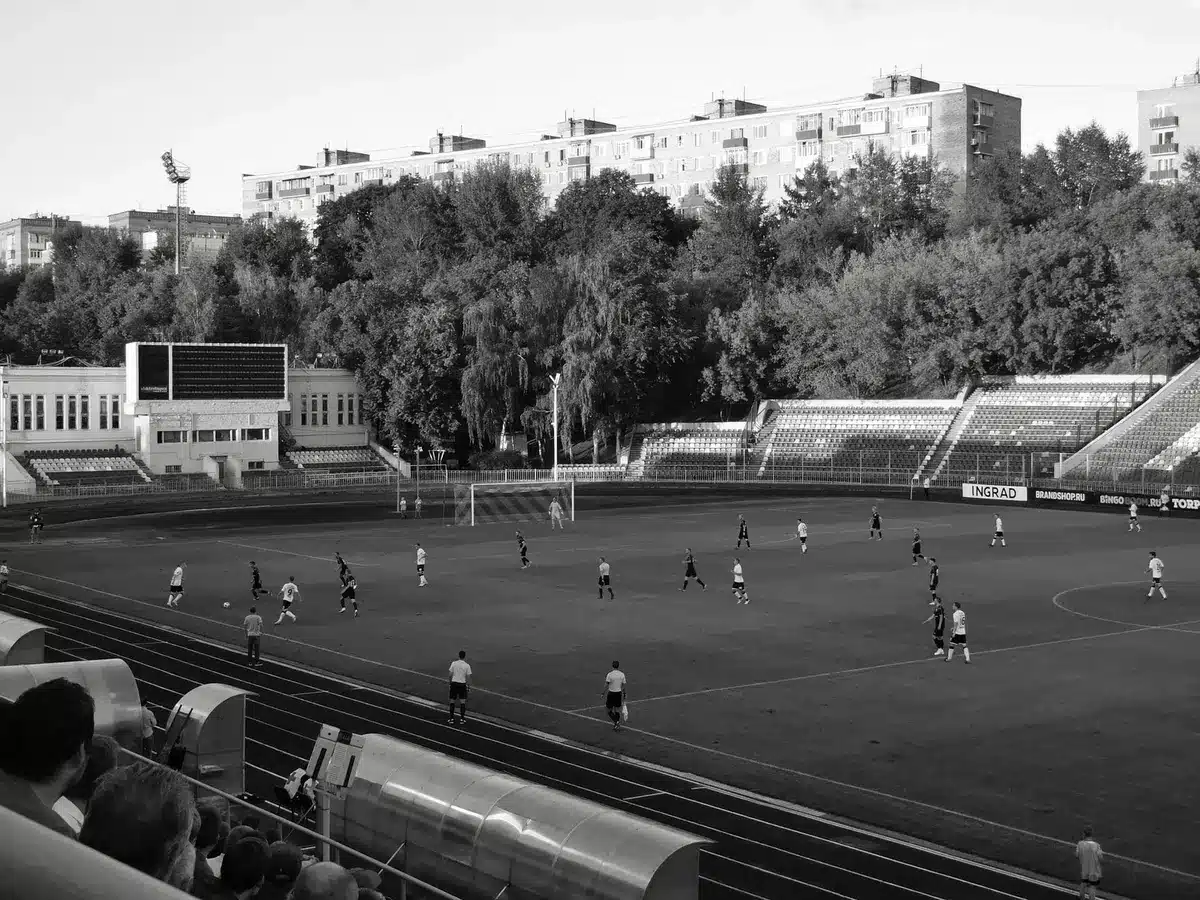 Spettatori allo stadio durante una partita di calcio serale con grande tensione