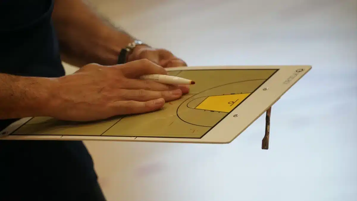 Allenamento di basket con istruttore che insegna tecnica ai giocatori