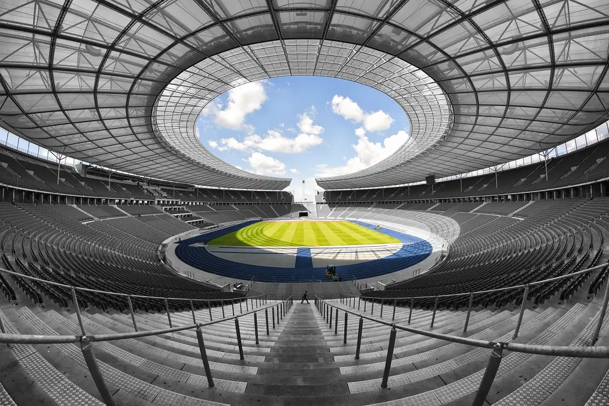 Folla in piedi che applaude durante una cerimonia in uno stadio illuminato