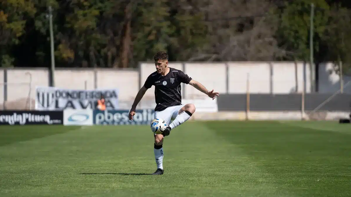 Giovane centrocampista in azione durante una partita di Serie B con pressione difensiva
