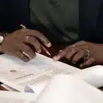 Documenti contrattuali e denaro su una scrivania, simbolo della trattativa di mercato calcistico
