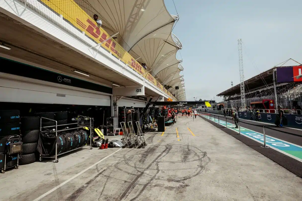 Ingegneri e tecnici di un team di Formula 1 in discussione strategica nel paddock