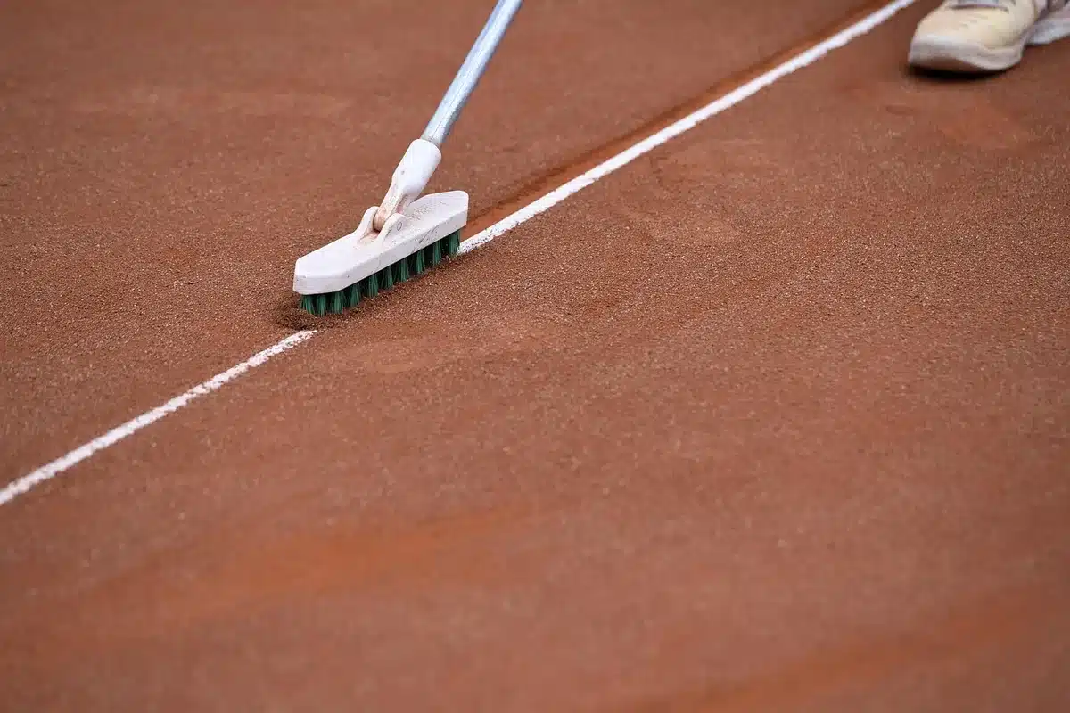 Corte di tennis professionale agli US Open con giocatrici in allenamento e stadio sullo sfondo