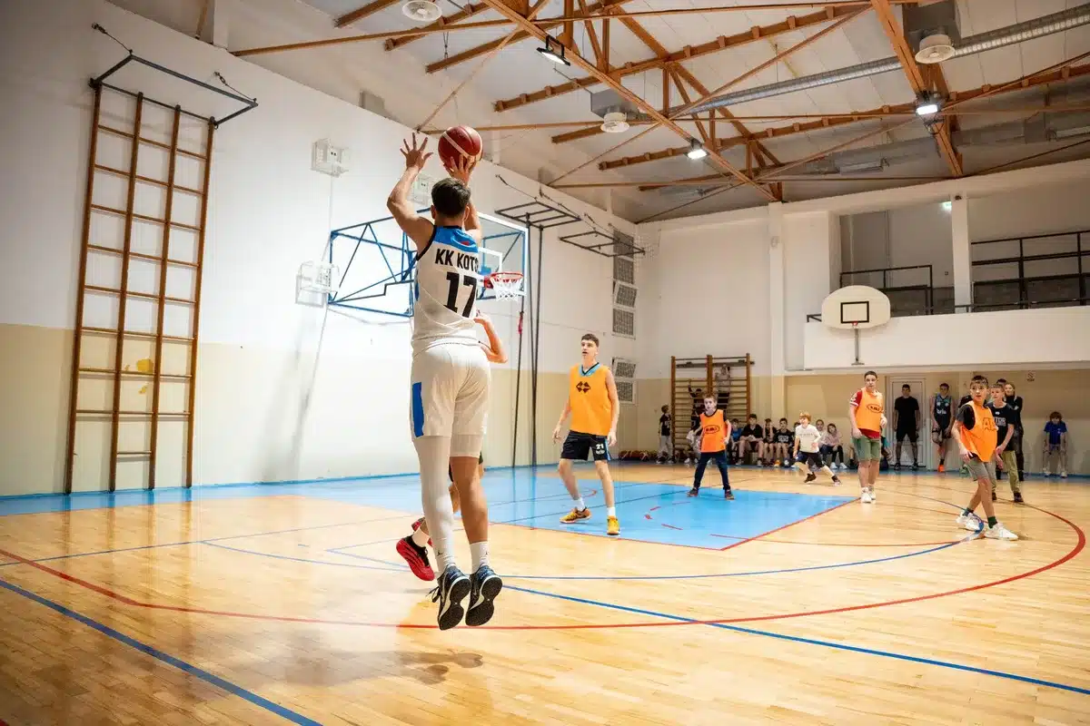 Squadra di basket durante il ritiro estivo, giocatori in palestra con allenatore