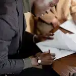 Firma di un contratto di acquisizione aziendale, documenti finanziari su tavolo riunioni