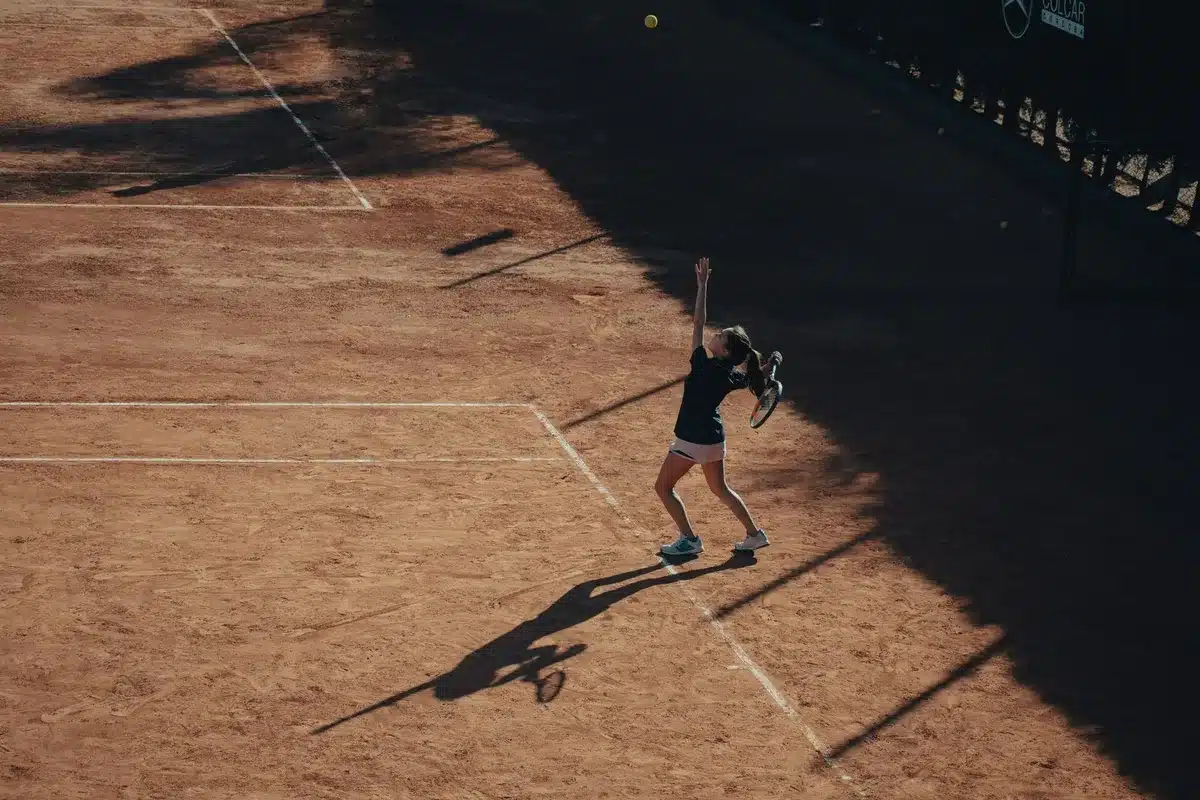 Due tennisti in scambio veloce su campo in cemento, racchette alzate durante il colpo
