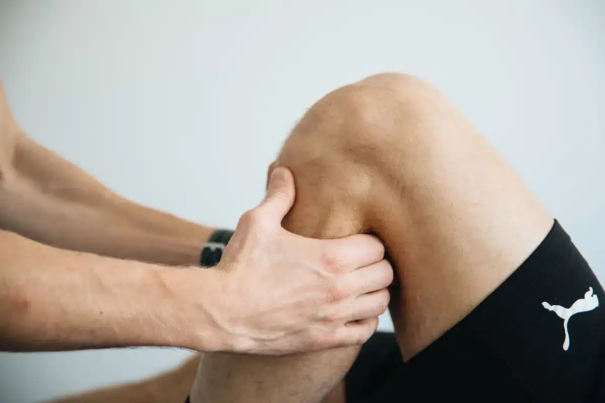 Fisioterapista che tratta il ginocchio di un tennista durante la riabilitazione
