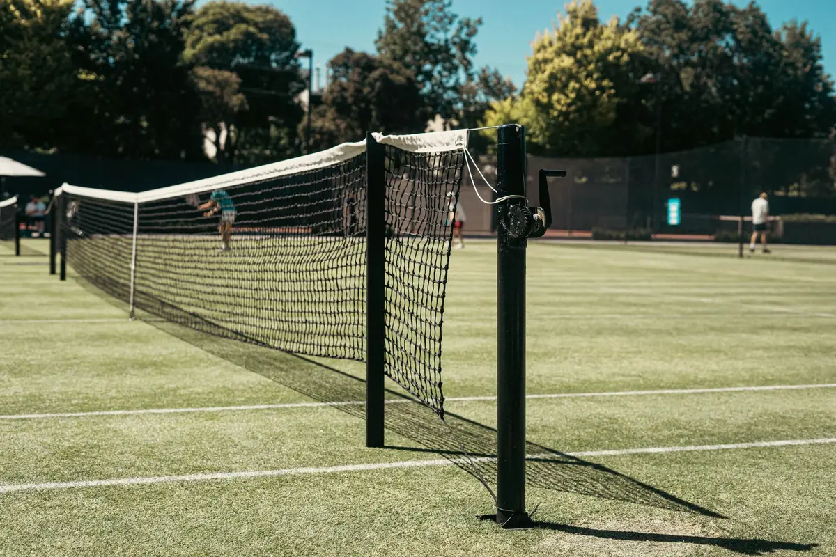 Due tenniste si stringono la mano a rete dopo una finale di doppio femminile