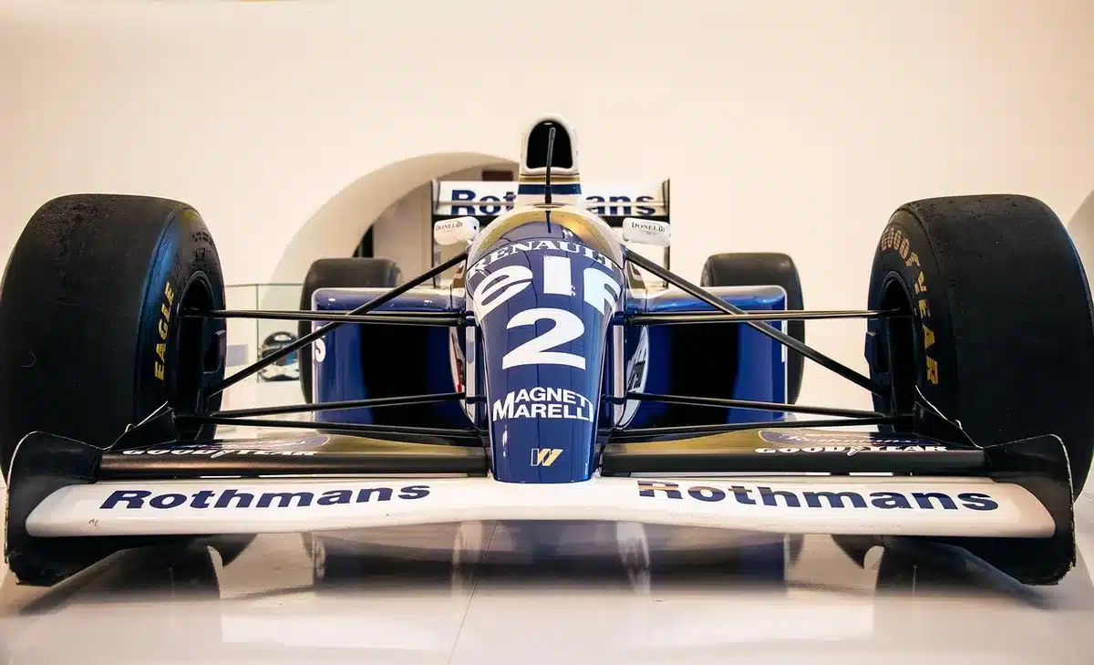 Monoposto in sorpasso a Monza con tribune in lontananza