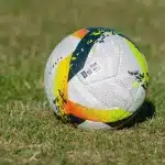 Calciatore in azione durante una partita di Serie B sotto i riflettori dello stadio