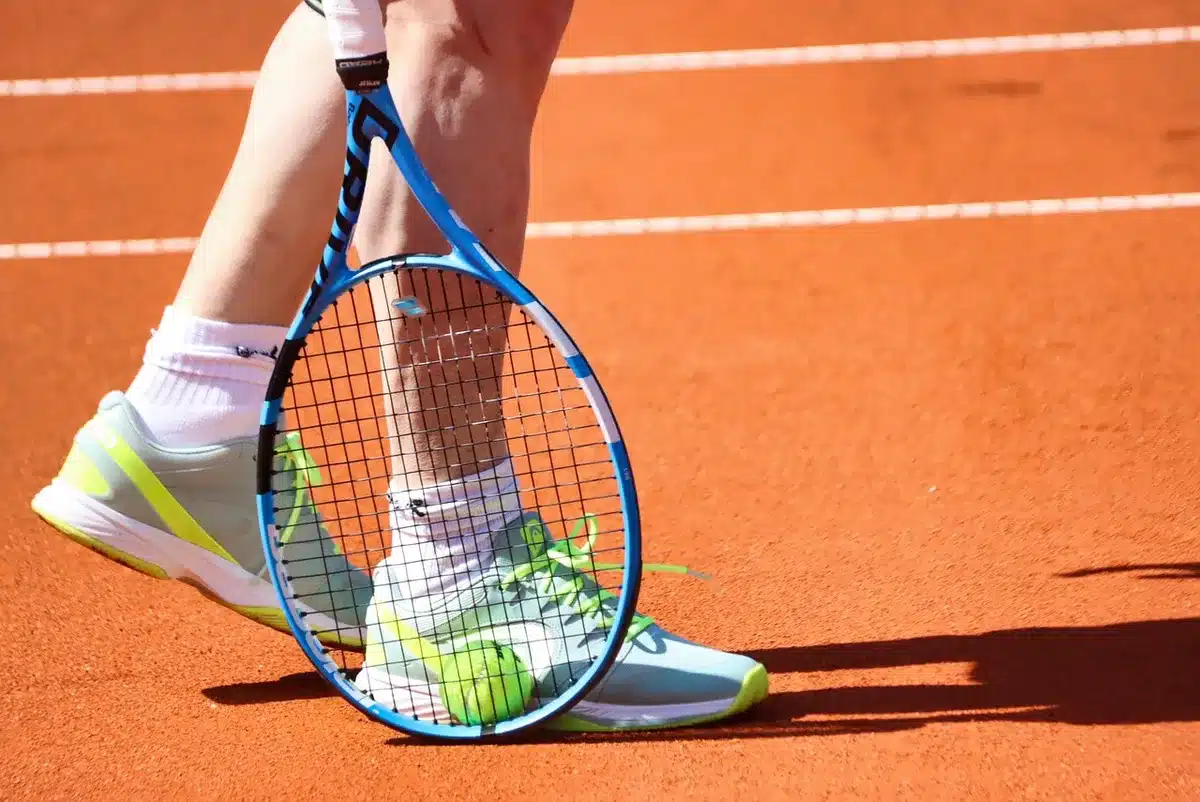 Giocatrice di tennis che rientra in campo con il suo coaching team