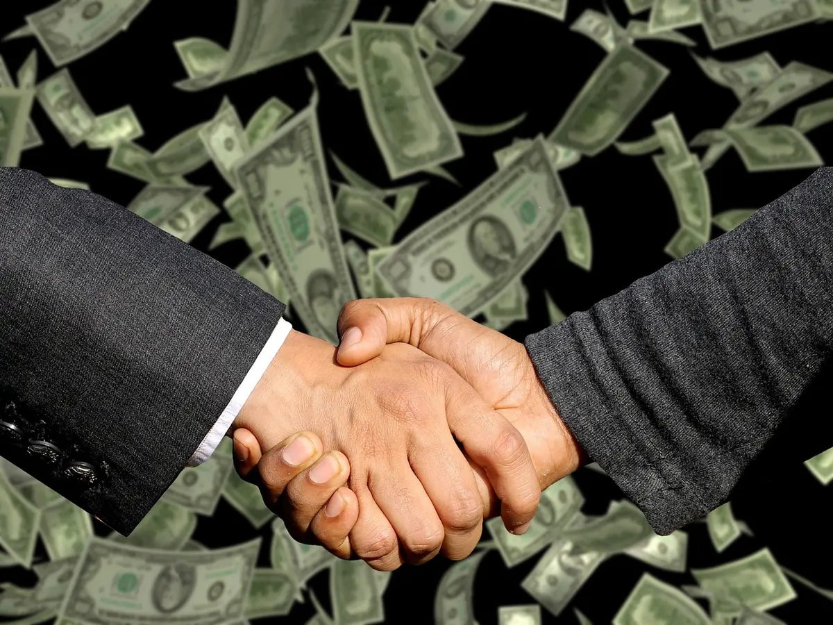 Documenti contrattuali e cifre economiche su un tavolo di trattativa