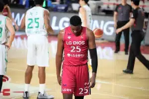 Campo da basket vuoto con panca e una lavagnetta, silhouette sullo sfondo