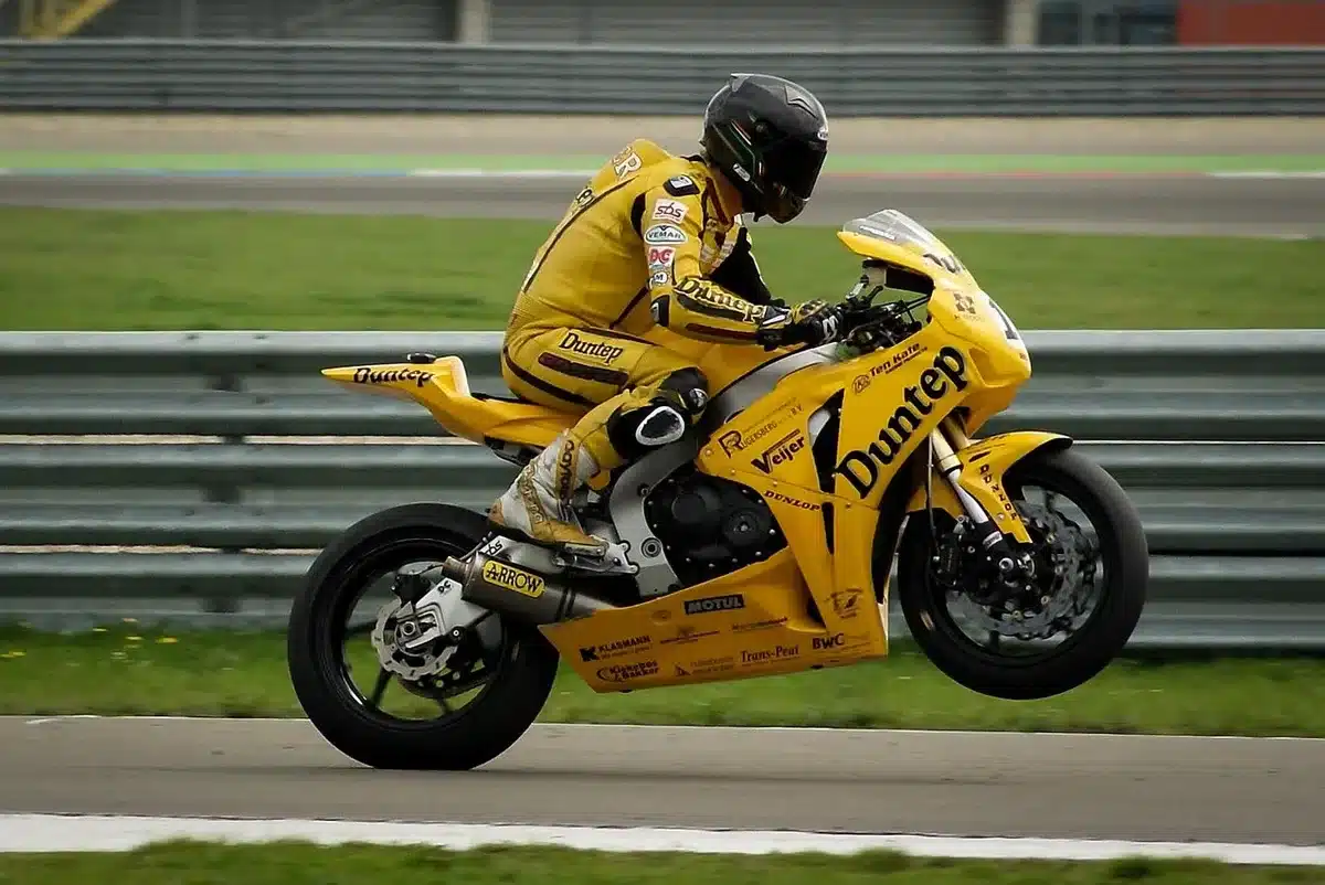 Uscita pitlane con moto da corsa e meccanici, scena anonima in linea con le nuove regole