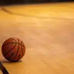 Palestra di basket vuota con scarpe da gioco e palla vicino alla linea dei tre punti