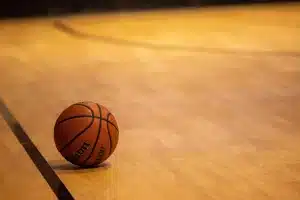 Palestra di basket vuota con scarpe da gioco e palla vicino alla linea dei tre punti