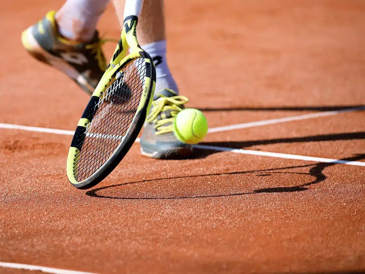 Campo da tennis vuoto al tramonto con racchette appoggiate alla rete
