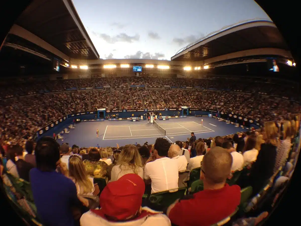 Folla anonima e racchette al tramonto in uno stadio di tennis