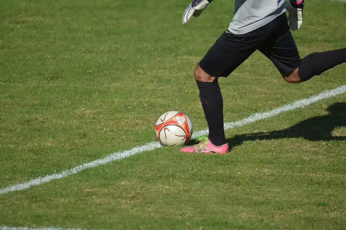 Calciatore che mette il pallone sotto la maglia durante la celebrazione