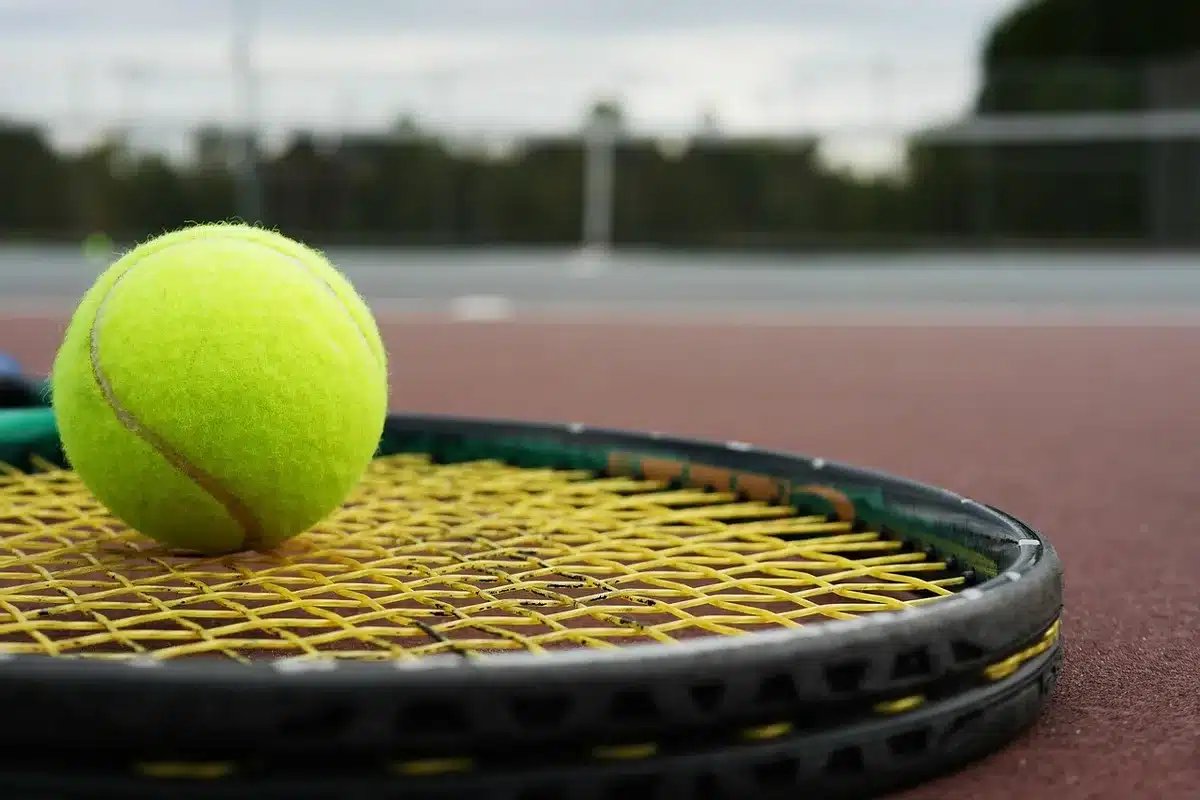 Campo da tennis coperto con racchetta e borsa, atmosfera di preparazione