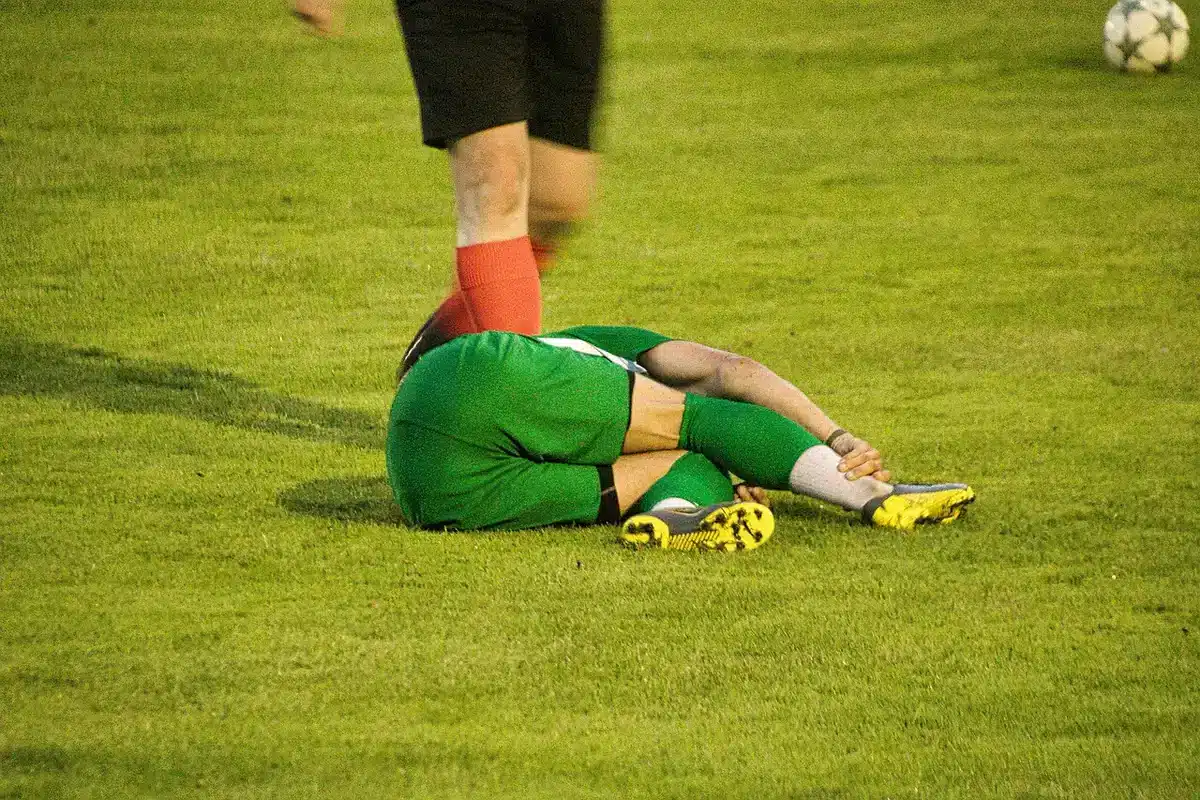 Giocatori in campo esultano dopo un gol con panchina alle spalle